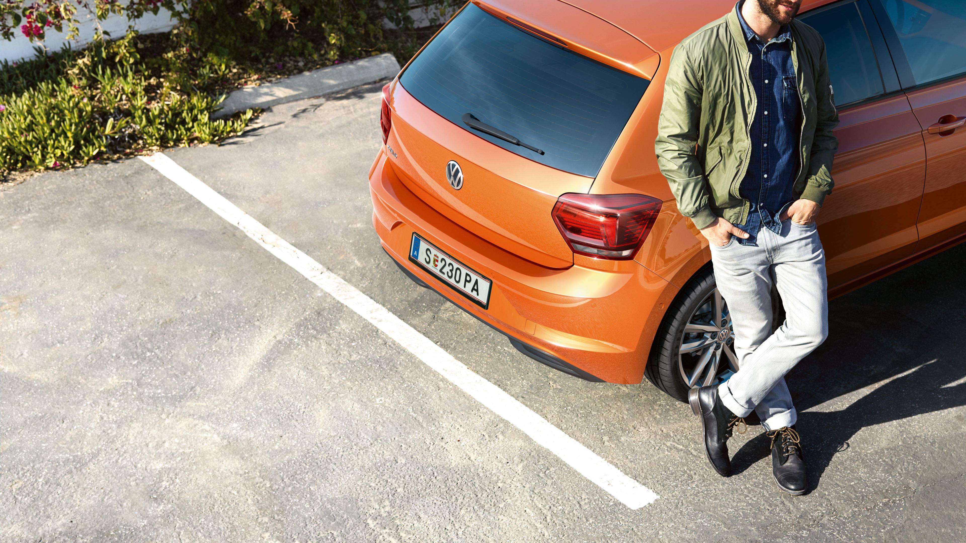 Ein Mann lehnt am Heck eines VW Polo