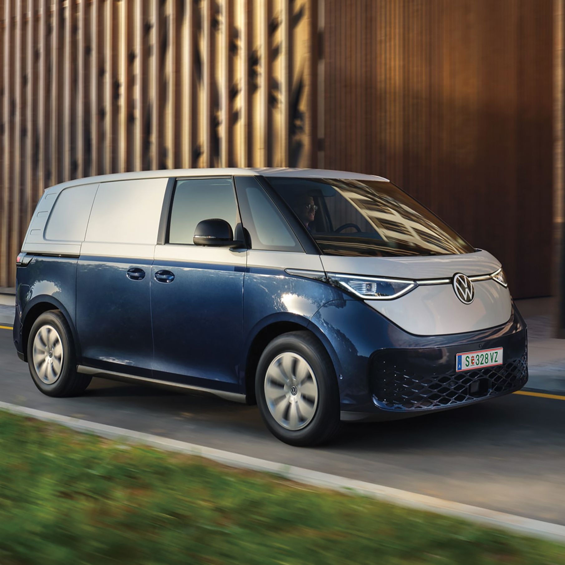 Blauer ID. Buzz fährt entlang einer einspurigen Straße