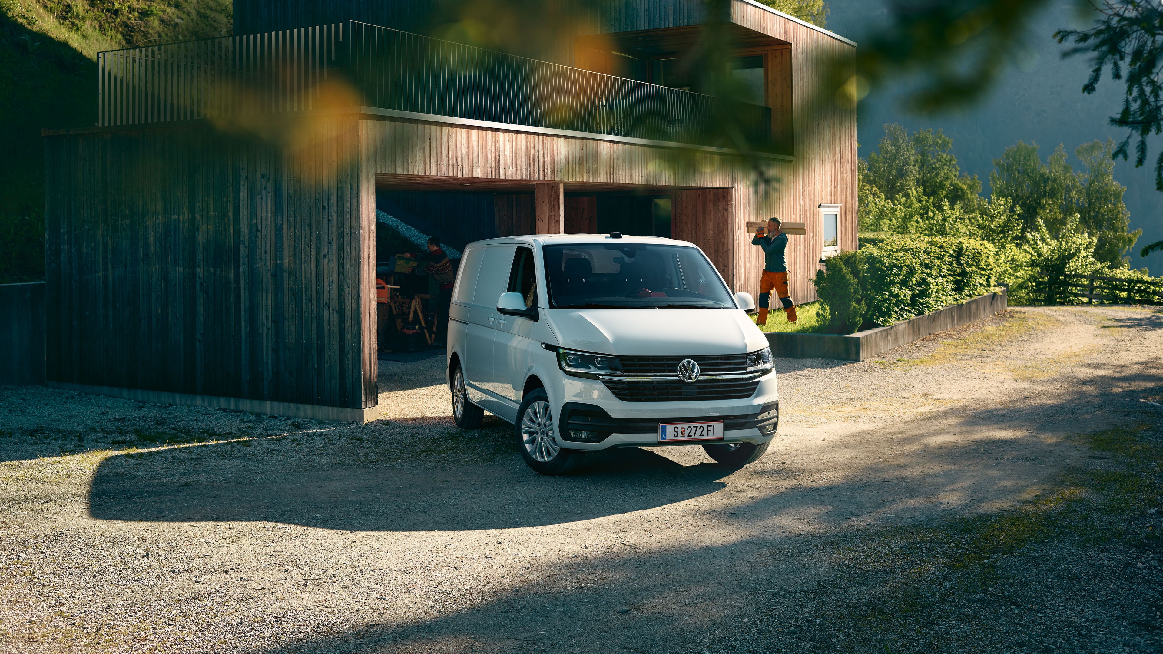 Weißer VW Transporter parkt vor einem Haus
