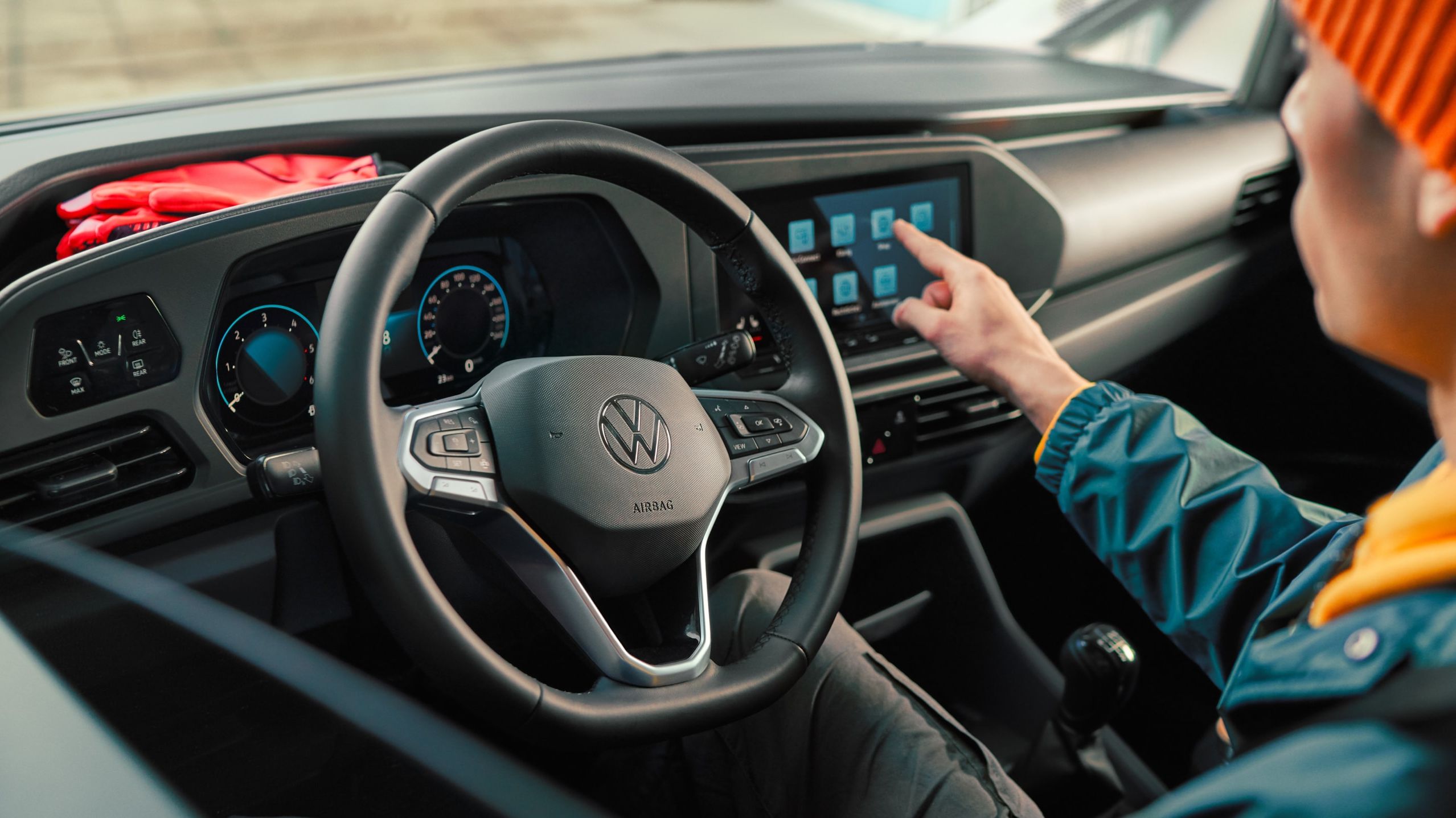 VW Caddy Kastenwagen steht bei Gebäude und wird beladen.