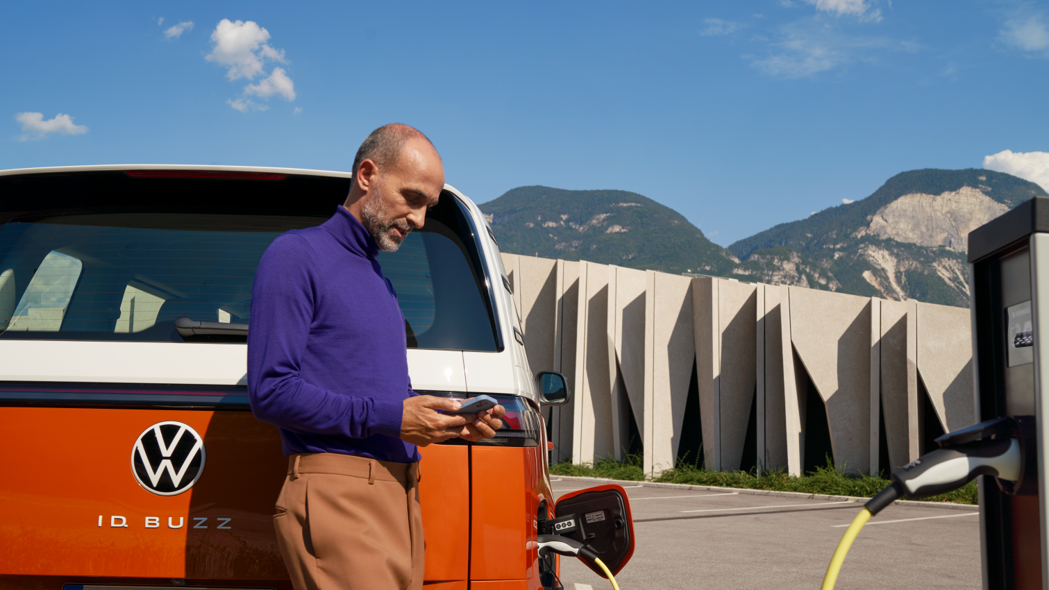 Mann steht hinter ID. Buzz und bedient Smartphone