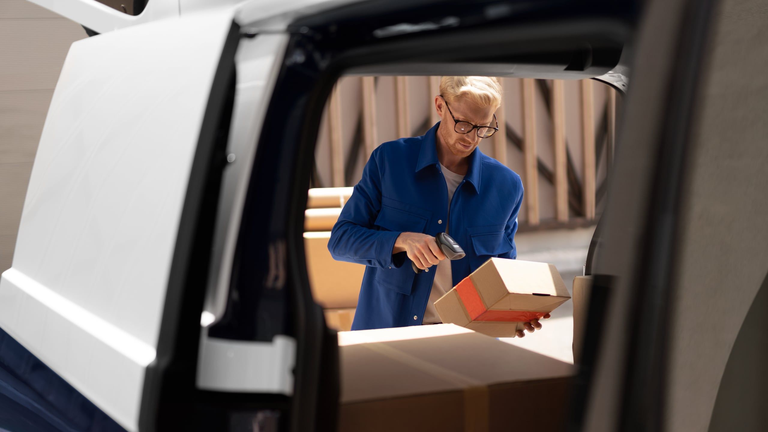 Blick durch den Laderaum des ID. Buzz Cargo von Schiebetür zur Heckklappe mit Sicht auf Paketboten