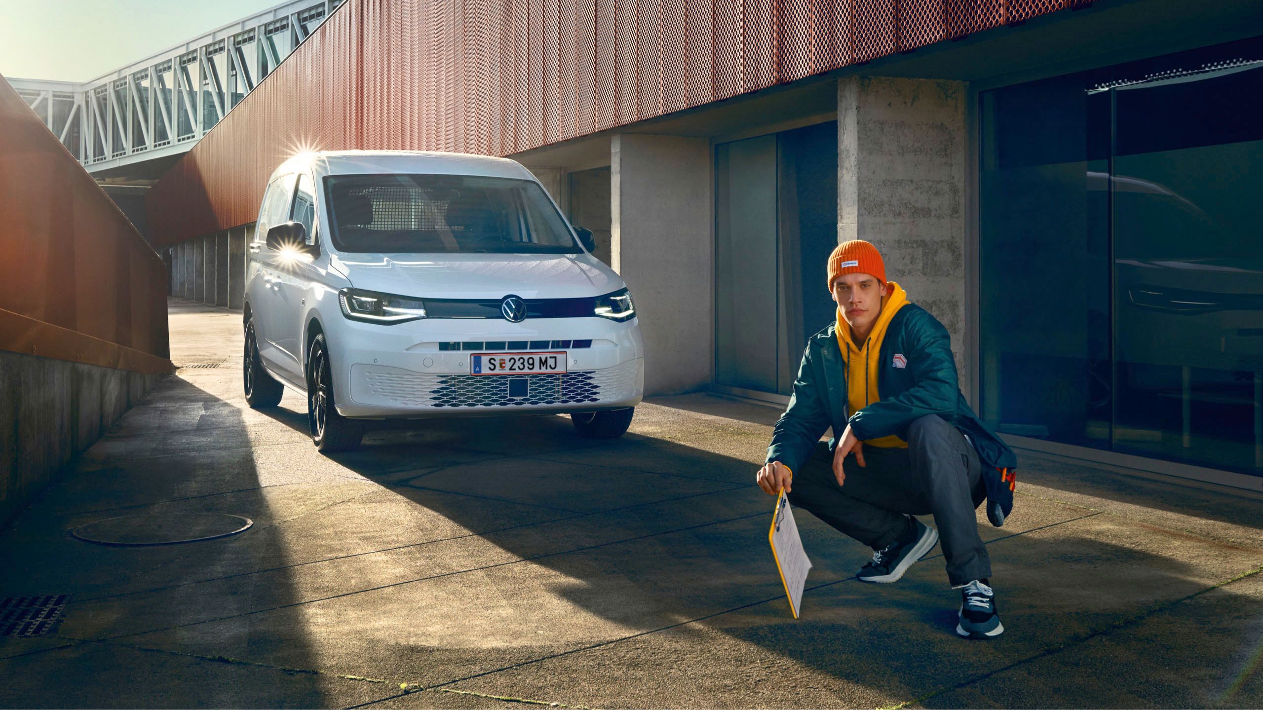 Weißer VW Caddy Kastenwagen fährt durch Stadt