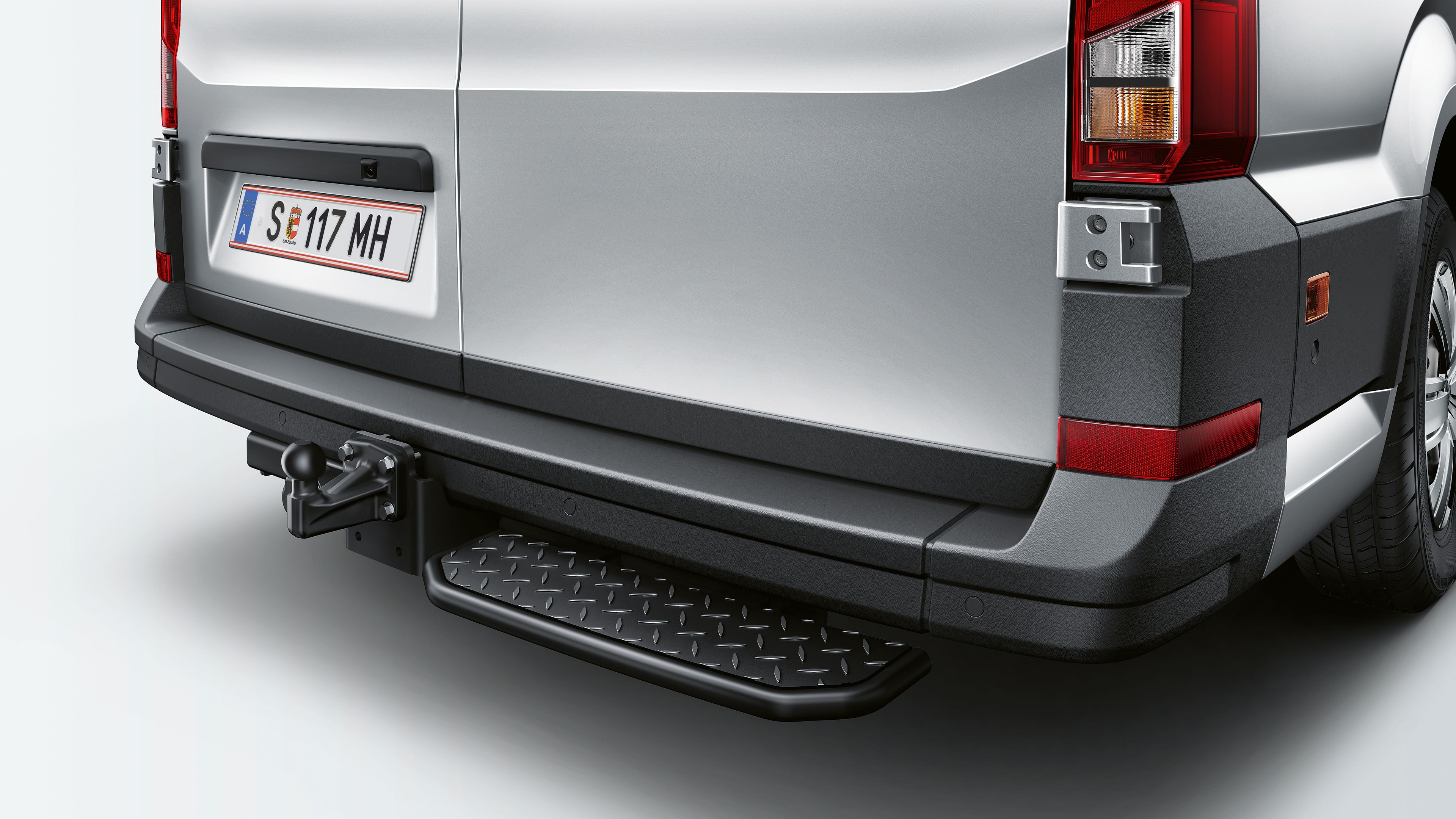 Detailaufnahme einer halbseitige Trittstufe im Stoßfänger eines VW Crafter Kastenwagens.
