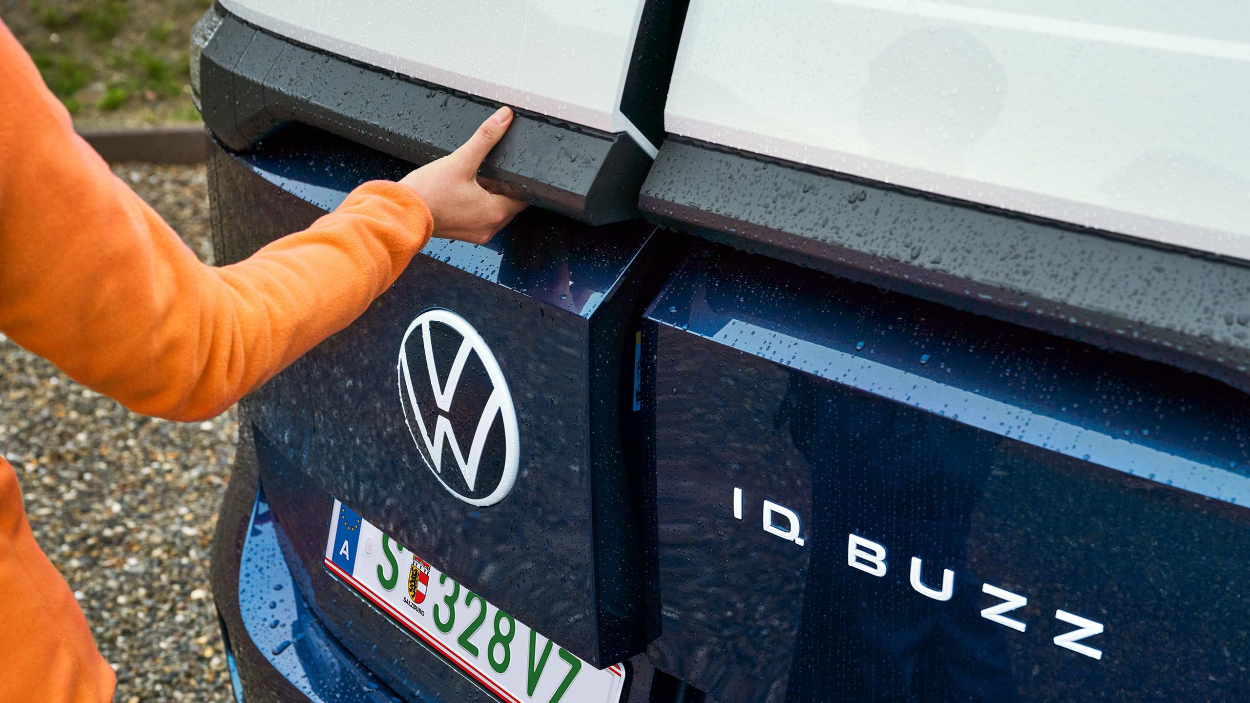 Die Heckflügeltüren eines blau weißen ID. Buzz Cargo werden per Hand geöffnet