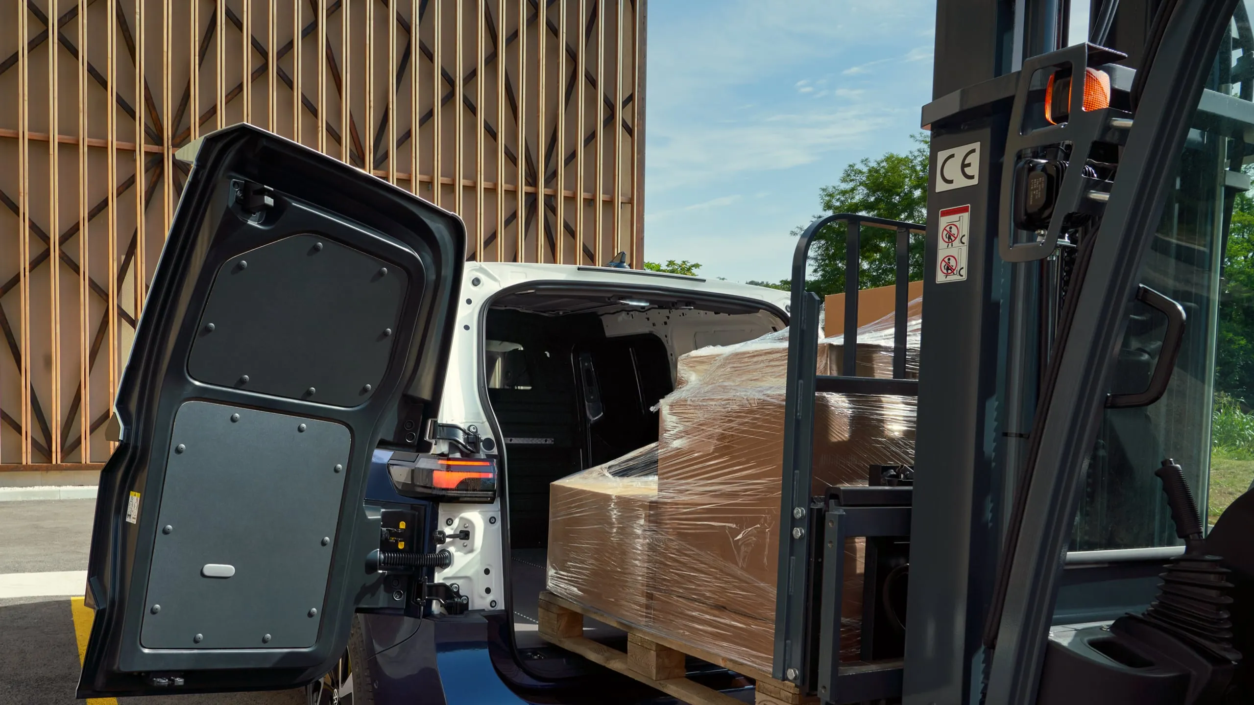 Ein weiß blauer ID. Buzz Cargo mit Heckflügeltüren wird mit einem Gabelstapler beladen