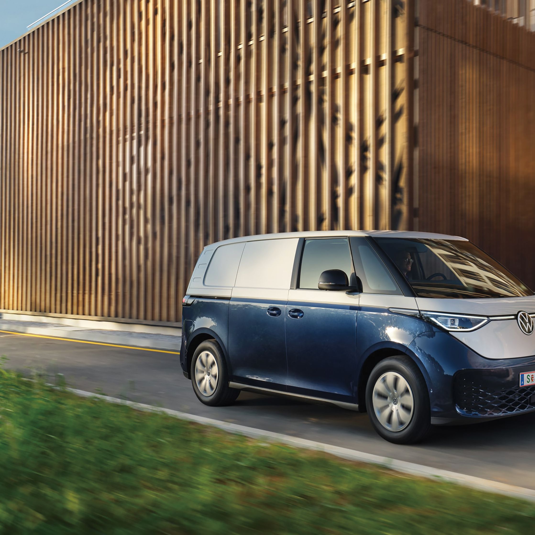 Blauer ID. Buzz fährt entlang einer einspurigen Straße